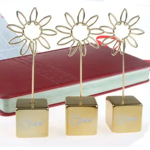 memo clips in gold with a flower shape on the top and a cubic base